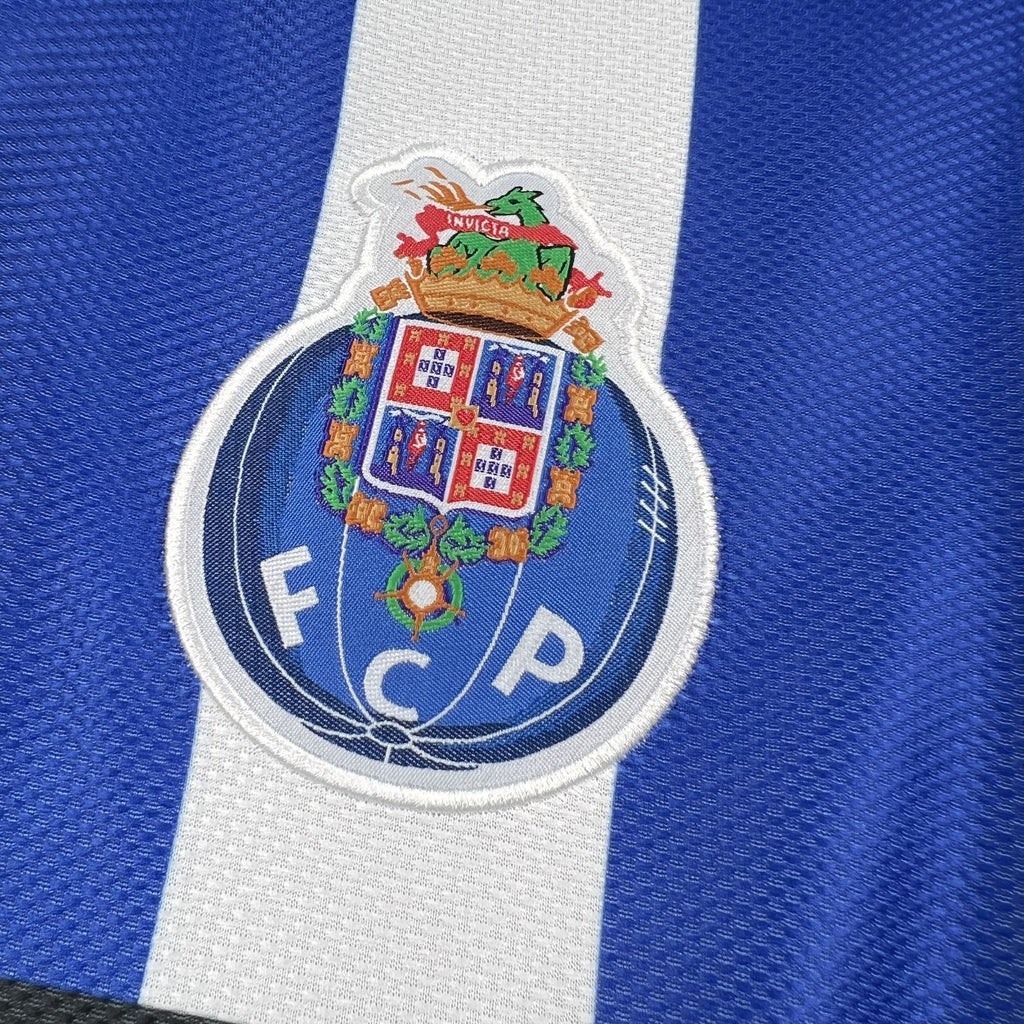 Embroidered FC Porto crest patch on a white vertical panel of a blue jersey