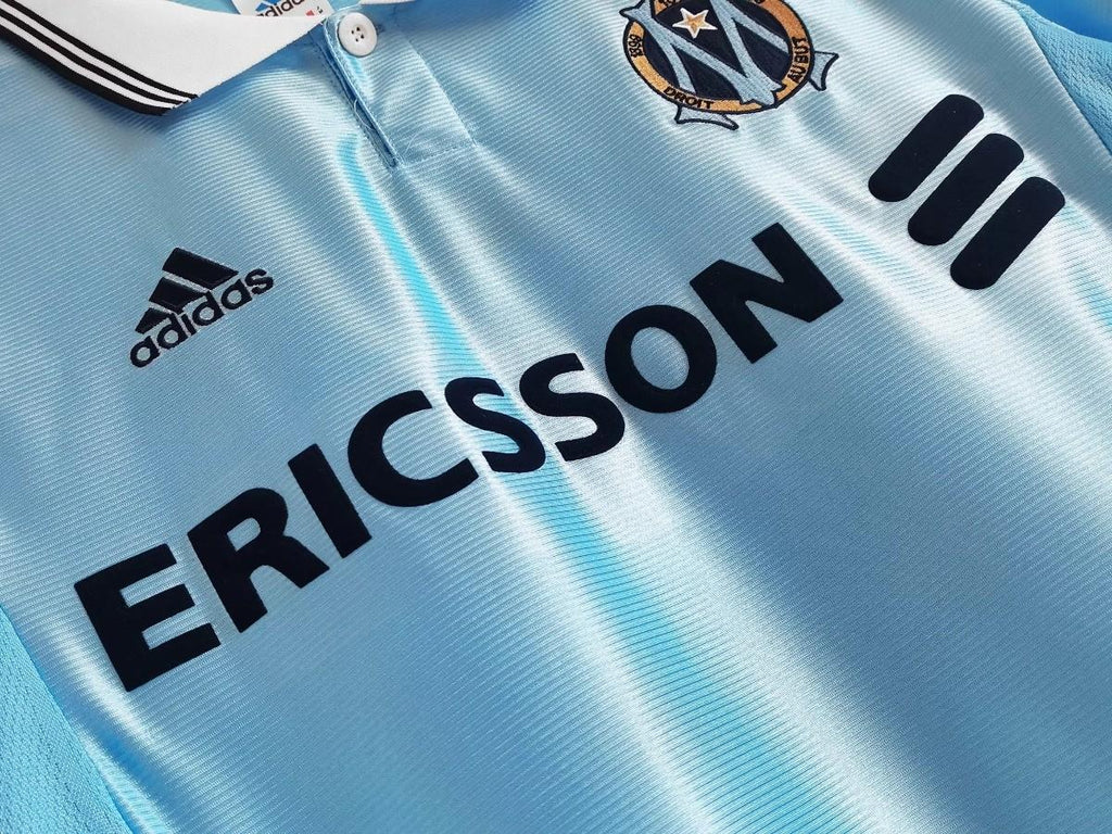 Sky blue soccer jersey front detail with ERICSSON sponsor and three black shoulder stripes