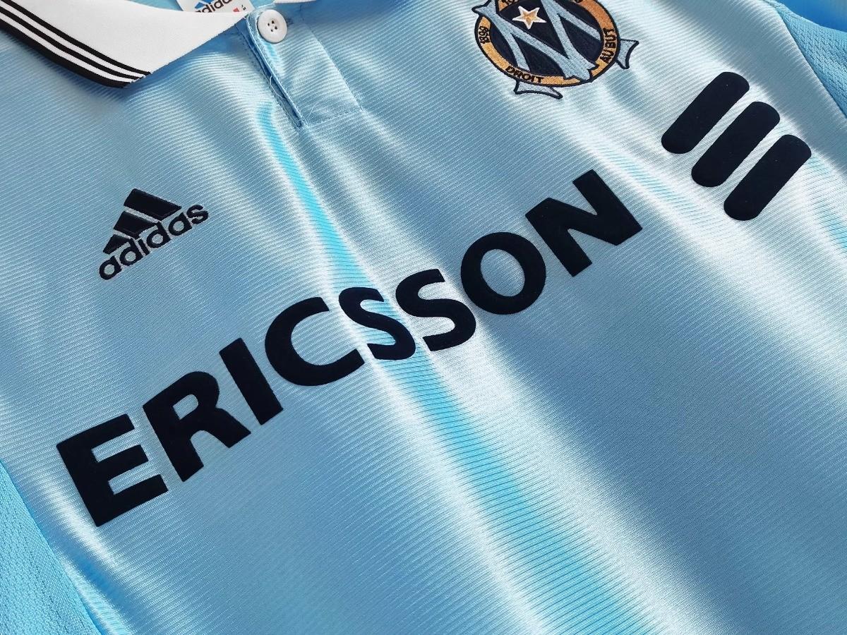 Sky blue soccer jersey front detail with ERICSSON sponsor and three black shoulder stripes