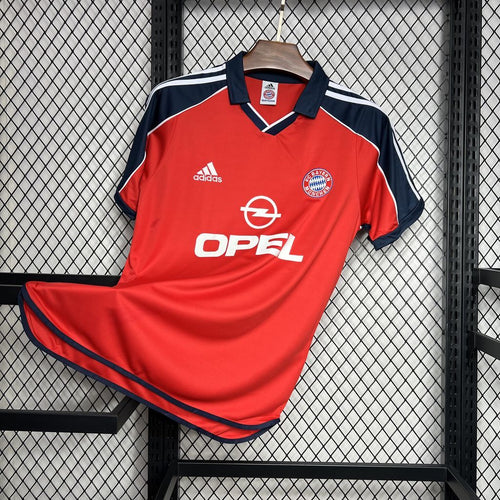 Red Bayern Munich retro soccer jersey on display with navy trim and white side stripes