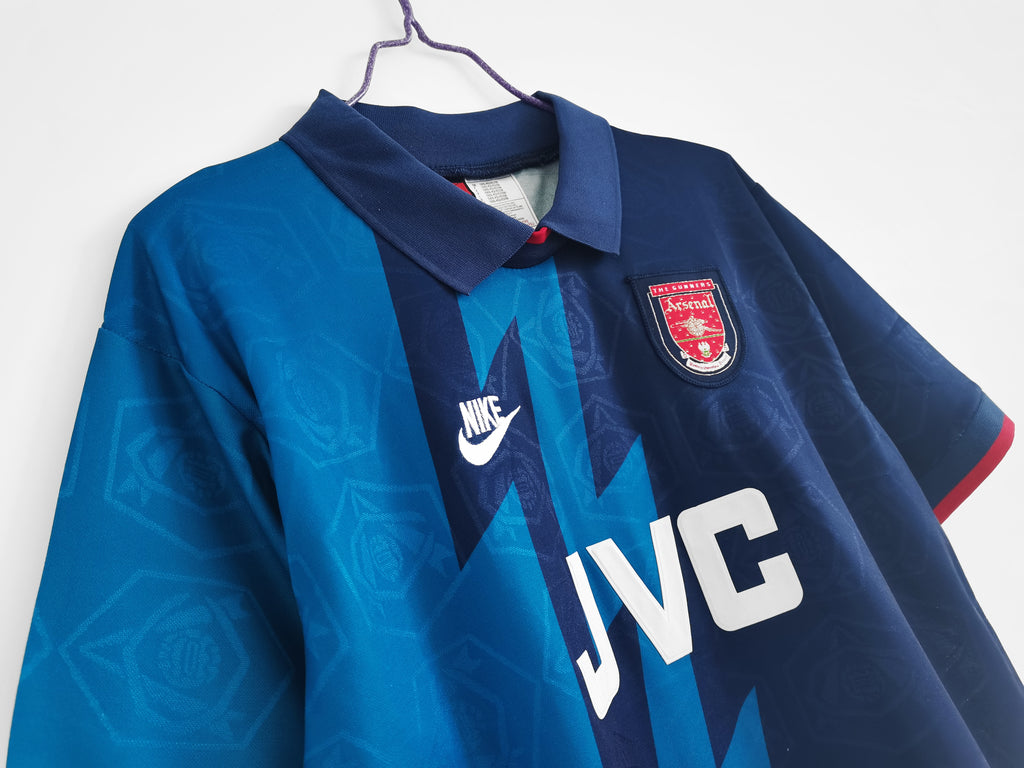 Retro football jersey front close-up, Nike swoosh, Arsenal crest, and JVC logo