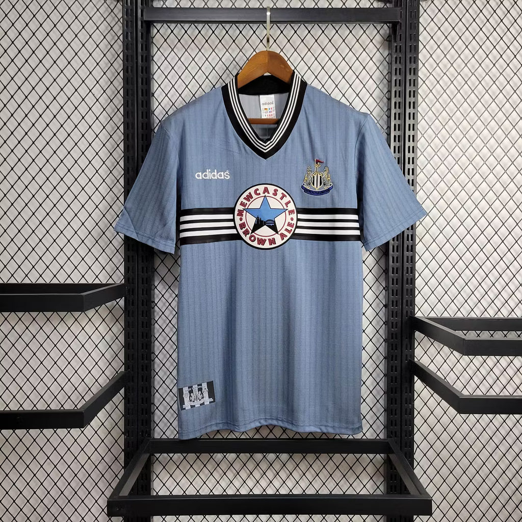 Light blue retro football jersey with V-neck, black-and-white collar stripes, club crest
