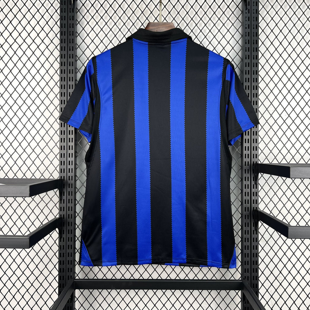 Back of home football jersey, black with blue vertical stripes and crew neck