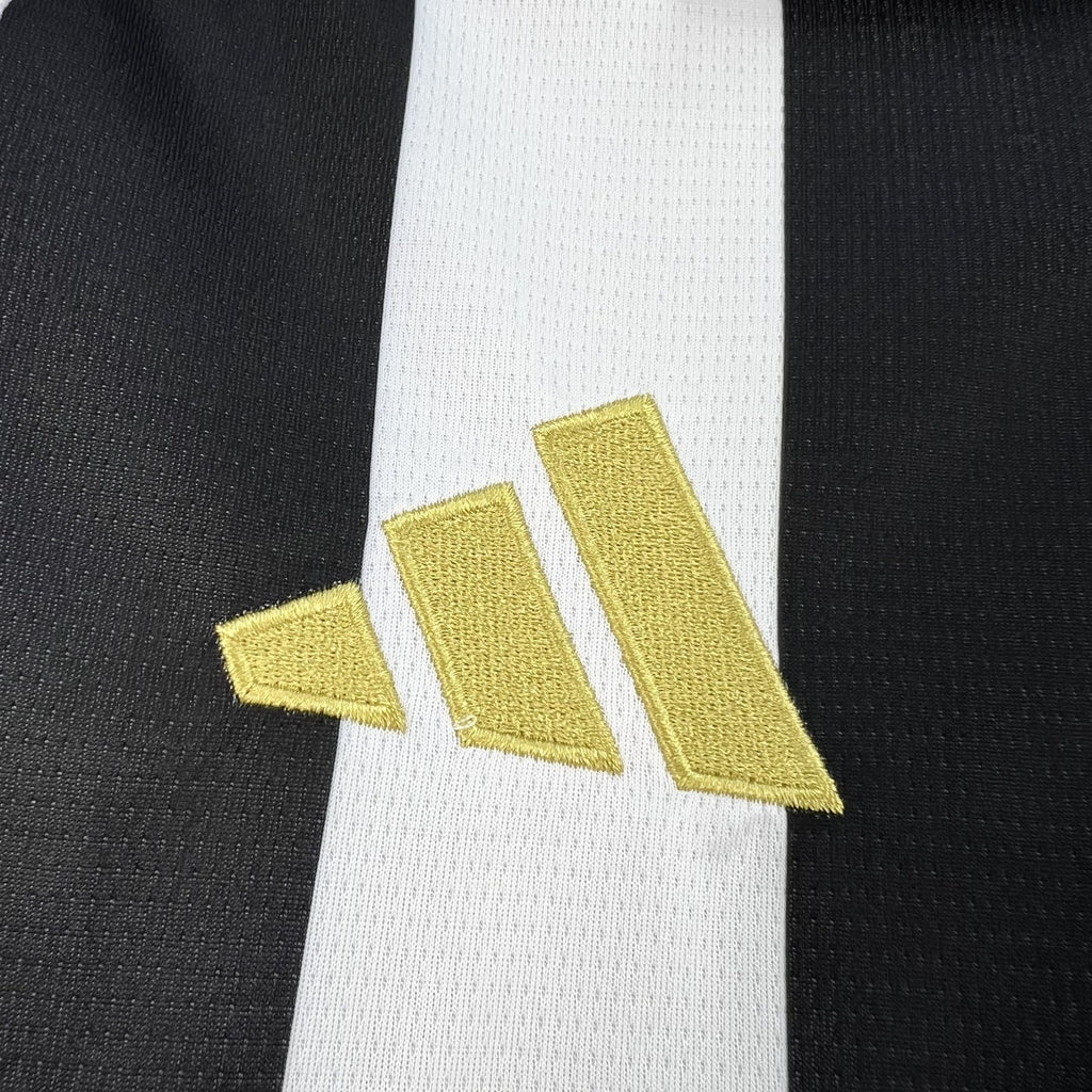 Gold logo on white sleeve panel of Juventus black and white striped home shirt